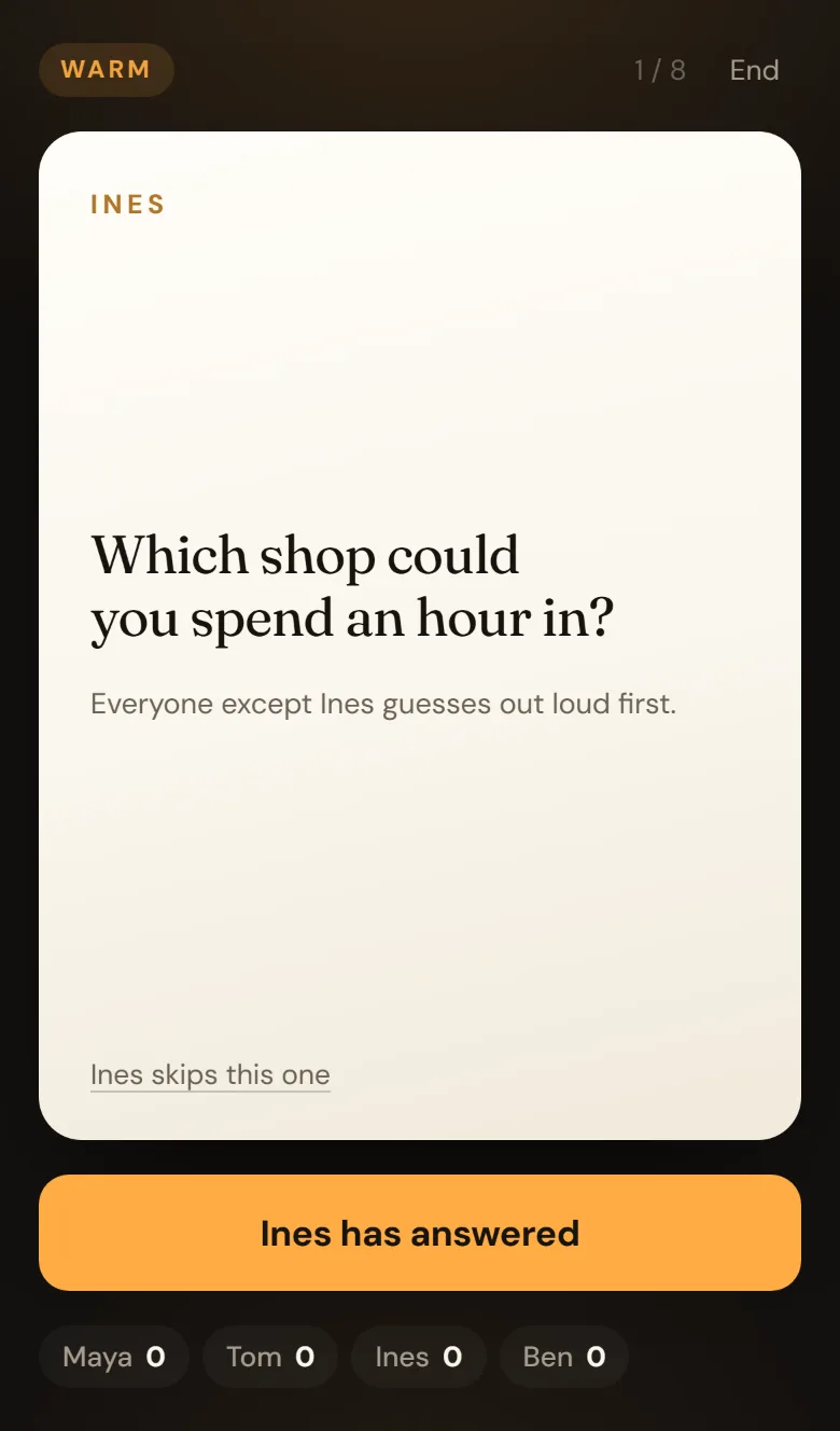 A warm-round card on a dark table: TOM, and the question What do you wear more than anything else you own? Below it, Everyone except Tom guesses out loud first, a skip link, and an amber button reading Tom has answered.